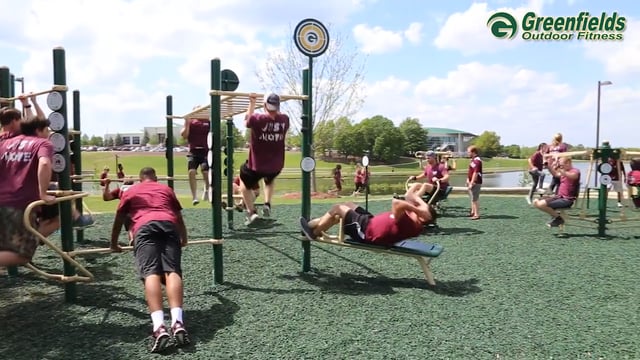 A group of students exercising on the 13-Person Cross Fitness Rig