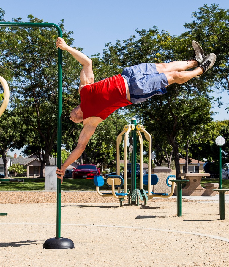 A man doing a human flag on a Flag Pole