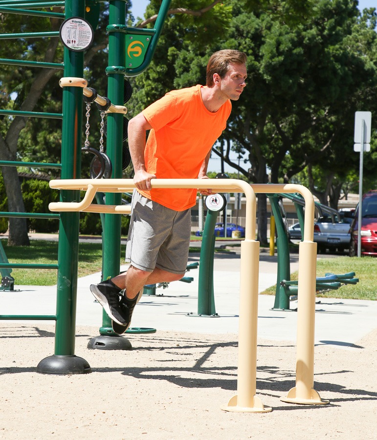 A man doing dips on parallel bars