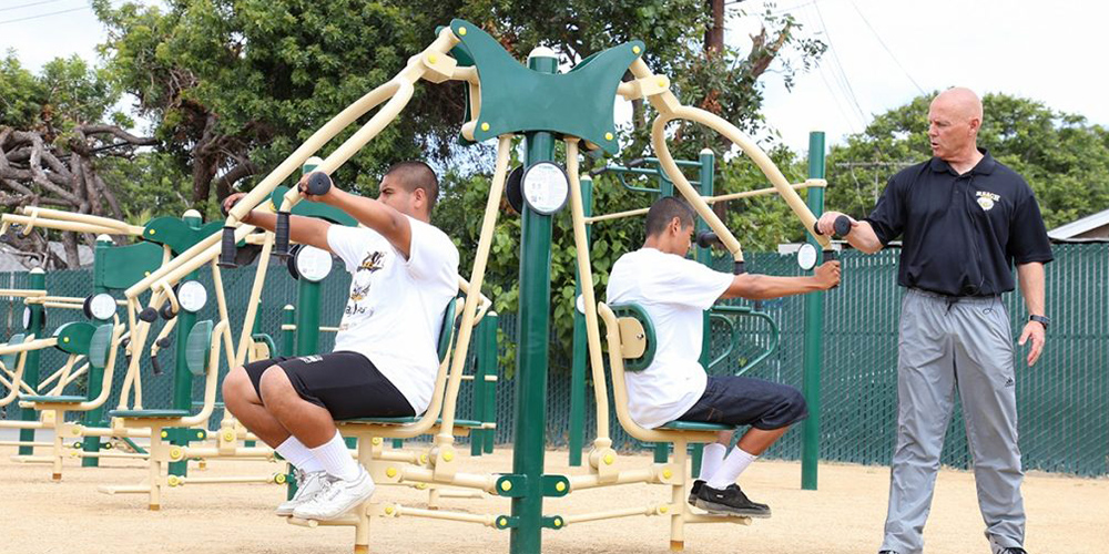 Students using outdoor fitness equipment